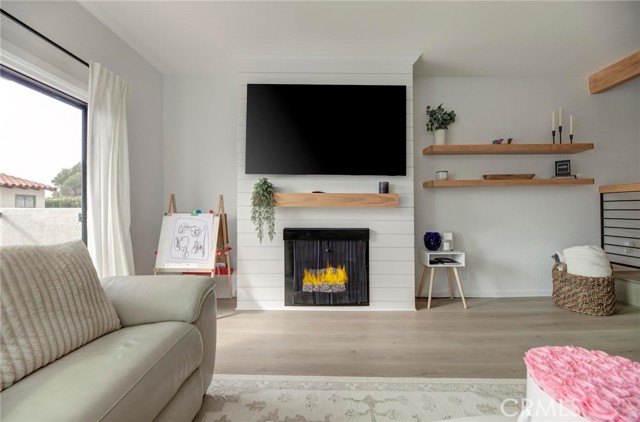 A custom fireplace and custom floating shelves are the focal point of this bright living room.