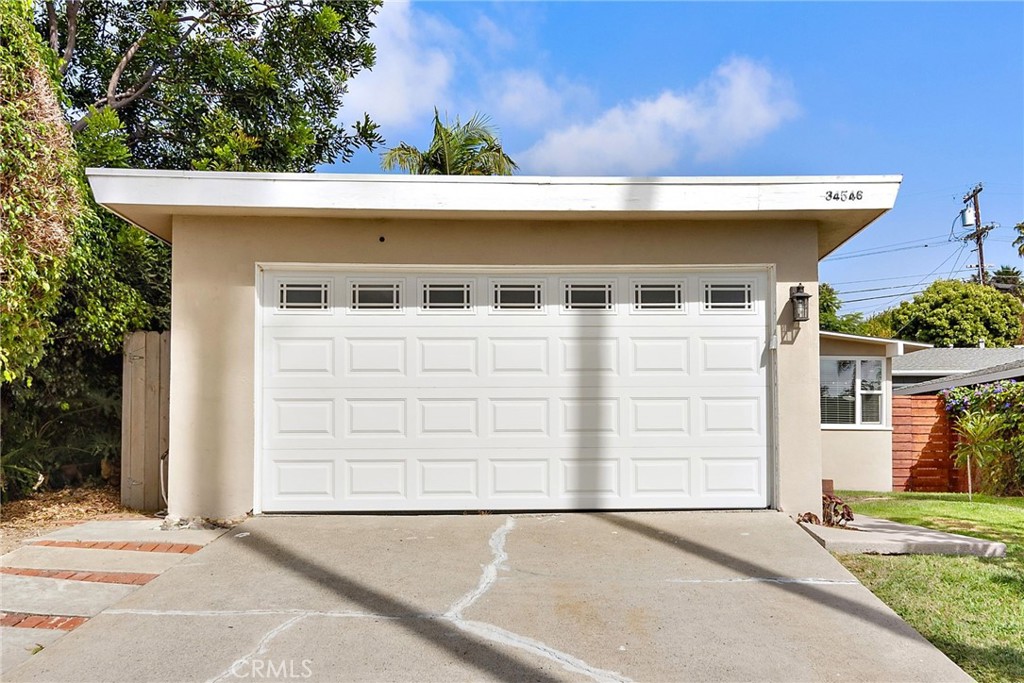 This delightful single-story home at 34546 Via Verde is nestled in the heart of Capistrano Beach, just three blocks from the scenic Dana Point bluffs. Offering a peaceful coastal lifestyle, this inviting residence boasts cool ocean breezes and easy access to the revitalized downtown Dana Point and Harbor. The private front porch invites you to relax while enjoying the landscaped yard with fruit trees. Inside, original hardwood floors and vaulted wood-beam ceilings add character and warmth to the space. Large picture windows in the living room bring in natural light, and the brick fireplace creates a cozy focal point. The kitchen is upgraded with dark wood cabinets, granite countertops, and modern appliances, with a skylight brightening the breakfast nook for a sunny start to your day. Each bedroom is comfortable and spacious, with the main bedroom featuring mirrored slider doors and a ceiling fan. Both bathrooms have been tastefully updated with modern finishes. Outside, the fully fenced backyard offers a private space for outdoor fun and relaxation, perfect for gatherings or quiet evenings. Located within walking distance to Palisades Elementary, Pines Park, and the beach, this home is a wonderful opportunity to enjoy everything Dana Point has to offer.