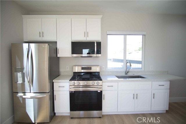 All new cabinets with new range, overhead microwave, and refrigerator.