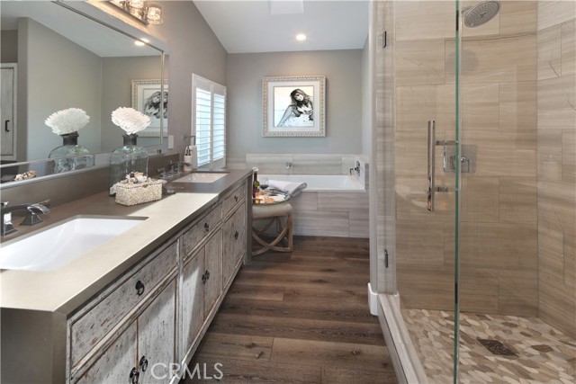 Primary bath boasts walk-in shower and separate soaking tub.