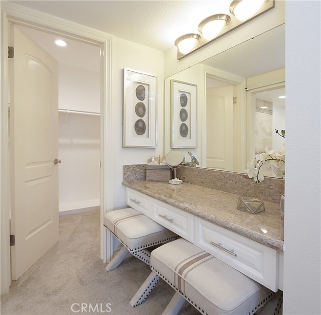 Vanity area outside of the primary bathroom and a second walk-in closet