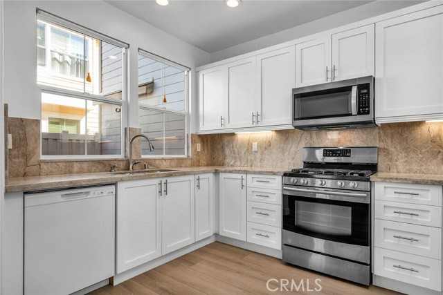 Kitchen with updated stone counters and cabinet doors, and appliances