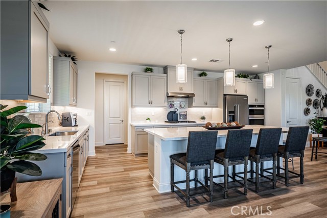 Your grand kitchen features a long storage closet to the right of the double ovens and is completely underneath the staircase! A great storage place! Your 10 foot quartz island is stunning with seating and tons of soft close cuboard space underneath. Stainless steel appliances and stainless steel hardware compliments your dolphin grey cuboards Doorway on the left side leads to your butlers pantry, a walk-in pantry and the 3 1/2 car garage entrance door.