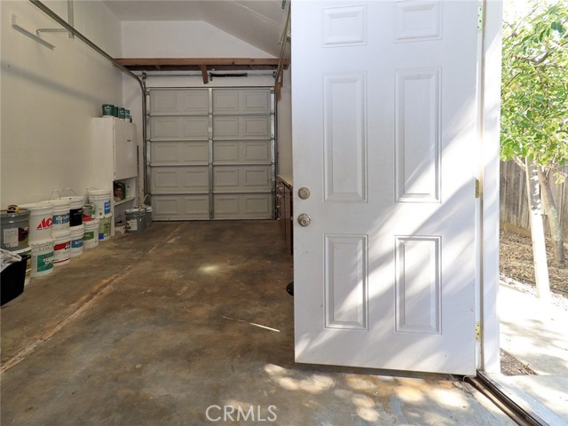 Single Car Garage/ Worktable/ ceiling access storage and door to side yard