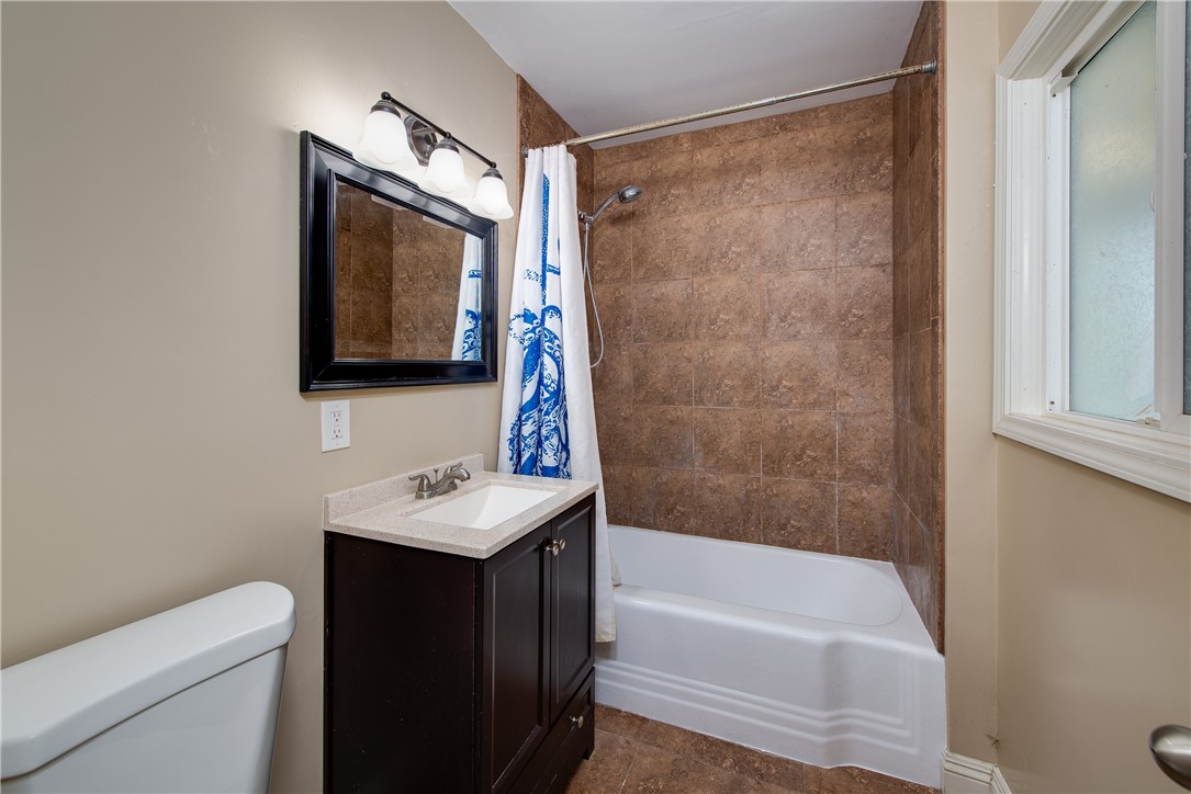 The hall bath has a bathtub that has just been re-glazed with a shower that is surrounded by tile.