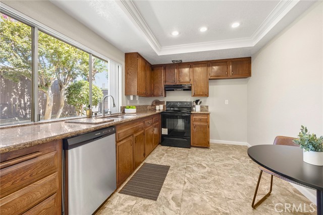 The kitchen boasts granite countertops, wood cabinetry a stainless steel sink and recessed lighting.