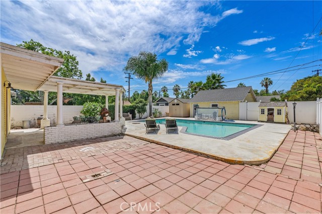 The backyard has endless possibilities with a shaded patio off the primary bedroom, and a large refreshing pool.