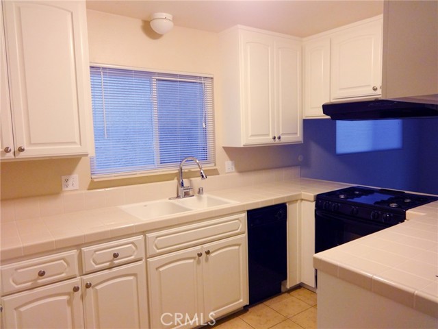 Another view of the kitchen showing the range and hood