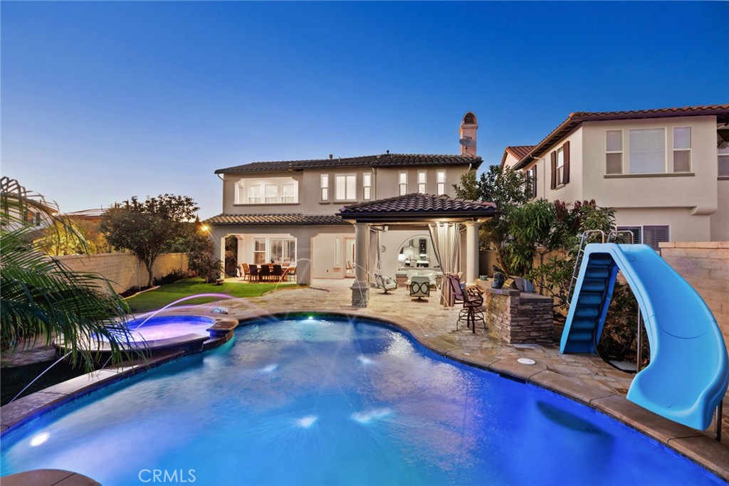 Enjoy this STUNNING entertainer’s home, with an 8,795 SqFt corner lot, featuring a sparkling saltwater pool & spa with kids waterfalls and waterslide, golf putting green, sandpit, a built-in BBQ island and a chic Capistrano room cabana with a built-in heater and outdoor surround sound. This beautiful lot is laced with custom stone hardscape and surrounded with multi-color roses and blossoming fruit trees including apple, pomegranate, grapes, peach, blood orange, avocado and citrus. This popular floor plan offers 5 bedrooms-including one MAIN LEVEL BEDROOM & BATHROOM-plus a separate master retreat off the master bedroom which can be a spacious office or den. Enjoy your morning coffee in the morning room off the kitchen with its own fireplace and large glass windows with views of the pool. The gourmet kitchen offers a spacious kitchen island laced with a custom lit up quartz countertop and WOLF stainless steel appliances including a cappuccino maker. Home has many upgrades throughout including plantation shutters, central vac system, built-in surround sound, custom built-ins and has a Crestron SMART-HOME system controlling the surround sound and interior lights. The master bathroom features his and her vanities, a jetted spa tub a spacious walk-in shower and has a very large walk-in closet with custom built-ins. Further features to this home include a 3-car tandem garage with epoxy flooring, reverse osmosis water system, two fireplaces-including one in the master bedroom-a side courtyard with a peaceful water fountain and a custom projection screen in the family room ready for movie night! This home offers a private corner lot location, providing a feeling of openness from the backyard and a peaceful view from the master deck. Kids can easily enjoy the short cul-de-sac street next to this lot on Calle La Espalda. Original owners have taken care of the property and enjoyed with their family. A true family home offering something every family member will love!