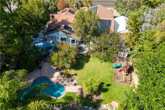 Welcome to 22210 Mission Hills Lane, a luxurious single-story haven nestled within the prestigious Hidden Hills neighborhood of Yorba Linda. Boasting 4 bedrooms and 2.5 bathrooms, this 2300 ft.² residence sits majestically on an expansive 25,500 ft.² lot reminiscent of a serene park-like oasis.
Upon entering, you are greeted by the grandeur of the formal living room, adorned with cathedral ceilings, recessed lighting, and a charming fireplace. French doors beckon you towards the patio, offering a seamless transition between indoor & outdoor living. Adjacent to the living room is an elegant formal dining room, perfect for hosting intimate gatherings. The kitchen is a chef’s dream, featuring white cabinets and gleaming stainless-steel appliances. Enjoy picturesque views of the sprawling grounds from the kitchen and savor your morning coffee in the breakfast nook, which provides tranquil vistas of the lush surroundings. The family room, open to the kitchen, exudes warmth with its beamed ceilings, a second cozy fireplace, and captivating views of the magnificent backyard. The primary suite is a retreat in itself, boasting cathedral ceilings and French doors that lead to the patio, allowing for a private escape. The updated primary bath offers dual vanities, a soothing soaking tub, and a separate shower, creating a spa-like ambiance. Three additional spacious bedrooms are adorned with recessed lighting and frameless mirrored wardrobe doors, ensuring comfort and convenience. The outdoor space of this residence is truly remarkable, with amenities to suit every lifestyle. Dive into the inviting pool, play on the manicured grassy areas, or find tranquility by the koi pond. Meandering paths invite exploration, and there's a dedicated play area for the kids, ensuring hours of outdoor enjoyment. For the adults, a tiki bar promises endless entertainment. A three-car garage with temperature control and ample storage provides convenience, while RV parking with an electronic privacy gate adds a touch of exclusivity. Recent upgrades include fresh paint inside and out, new carpet, a brand-new state-of-the-art HVAC system, 42 solar panels, and a water softener that will leave your skin feeling silky and smooth. 
With its idyllic setting, luxurious amenities, and meticulous updates, this home offers the ultimate California living experience within the coveted Hidden Hills community of Yorba Linda. There is also plenty of room on this property for an ADU/Guest House.