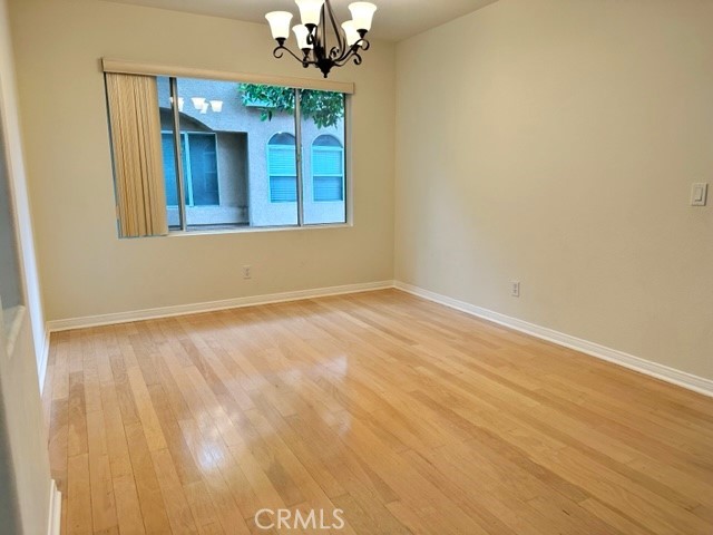 Separte formal dining room with laminated wood flooring with an arched entry to the kitchen.