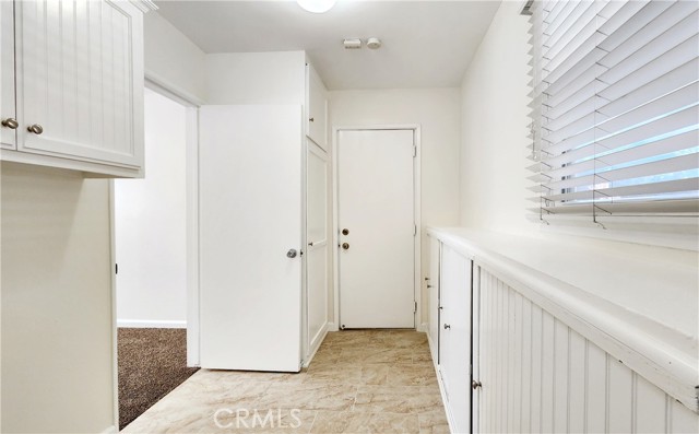 Spacious Laundry Room with Storage Cabinets and Pantry