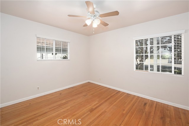 BEDROOM DOWNSTAIR WITH CEILING FAN AND WOOD FLOORS