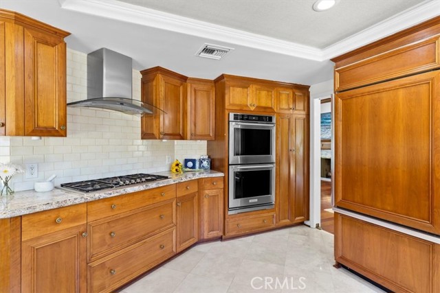 Kitchen with cooktop, double wall ovens and built in refrigerator.