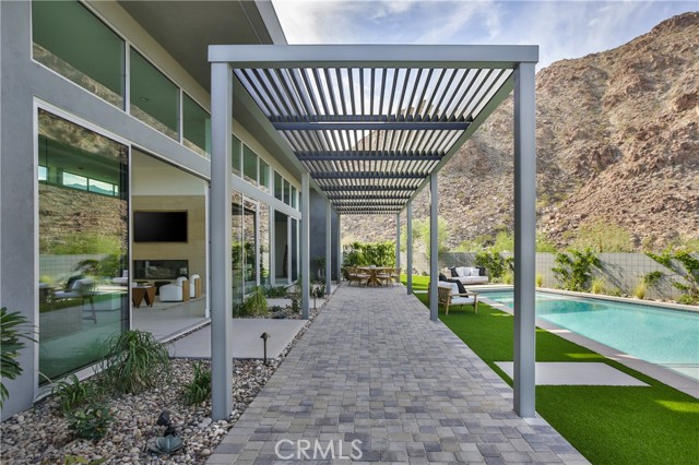 50067 Canyon View Drive Palm Desert, California Brand new modern home located in private gated club with ultimate mountain vista views. Seller credit for approved detached casita. Mid-century inspiration, high-end finishes. With its sensational entry and intimate mountain views, this private, contemporary new construction is both classic and serene. The front entry opens to a spacious yard with custom built bbq, pool, spa and outdoor shower, and large trellis for entertaining. Rich, colorful landscape and exterior tile and paved stones surround the space with 360 mountain views in the background. The home's main living area, which comprises living, dining, and kitchen, looks out to dramatic mountain views through an expansive wall of floor to ceiling glass. Highlights include tall ceilings, dual room fireplace, and sleek, modern appliances. Through the living and family room are three spacious en-suite bedrooms with the primary room boasting a large, luxurious bath with soak tub and modern finishes. Two spacious walk-in closets separate the bath and bedroom. Also in the primary bedroom are spectacular mountain views through private patio sliding glass doors, custom fireplace and media detail. This community offers the charm and allure of a traditional desert escape paired with many highly sought-after amenities and club offerings such as two championship caliber 18-hole golf courses, tennis & pickle ball, spa, health and wellness programs, wine club and gourmet cuisine, and more. Plans approved by HOA for ADU.