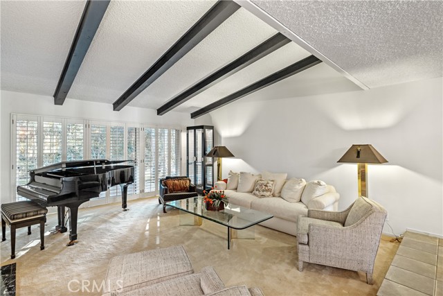 A perfect formal living room setting with tall ceiling and opening to the tranquil and beautifully landscaped backyard.