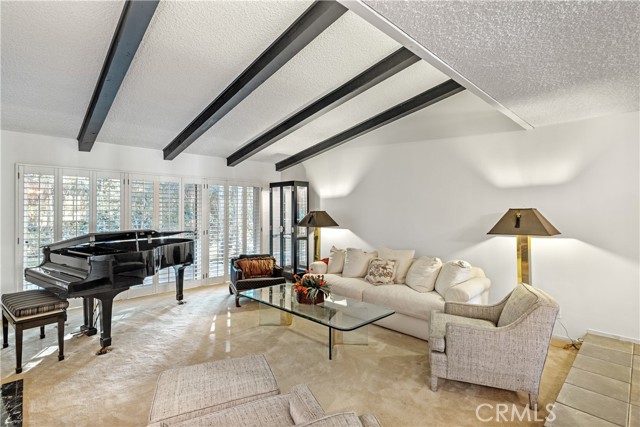 A perfect formal living room setting with tall ceiling and opening to the tranquil and beautifully landscaped backyard.