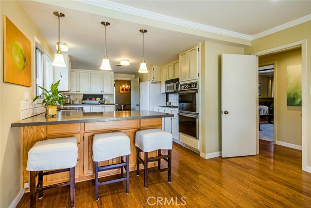 Looking from the family room into the kitchen with Ceaserstone countertops and a seating area at the bar.