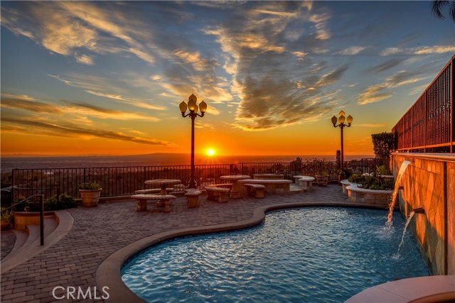 This exquisite residence, set in the prestigious 24-hour guard-gated community of Friendly Hills Estates, offers breathtaking views that encapsulate city lights, miles and miles of ocean from Newport Beach to Santa Monica, and the enchanting Palos Verdes Peninsula. Orange County to Downtown LA can be seen from this property. With high ceilings throughout, this stunning home blends elegance and comfort seamlessly. The spacious gourmet kitchen, a culinary dream, features an adjoining eating area, two pantries, a center island, high-end built-in appliances, 2 Sub-Zero refrigerators, water chiller, and a separate wine fridge. It opens up to mesmerizing city and night light views, with a hint of ocean on the horizon.

The formal living room is a masterpiece of luxury, boasting marble flooring, grand windows with opulent drapery, and a striking granite fireplace. The family room, a cozy retreat, presents panoramic views including Catalina Island, complemented by a granite fireplace, a balcony overlooking the backyard, and a separate bar area with granite countertops and a sink for entertaining.

Accommodations include two guest bedrooms on the lower level, with a jack and jill bathroom. A custom-made curved wooden staircase leads to the upper-level bedrooms and library, each room offering private bathrooms with granite countertops, marble flooring, and private balconies with awe-inspiring views.

The master suite is a sanctuary of its own, featuring a large bathroom with a jacuzzi tub, separate steam shower, double sinks with granite countertops, heated floors and a spacious walk-in closet. The backyard is a haven for relaxation and entertainment, showcasing stunning city and ocean views, a pool with a waterfall, a built-in fireplace and barbecue, a sink, and areas for gardening, including a section for planting vegetables.

Additional features of this remarkable home include a three-car garage with ample storage space, whole house surround sound system, proximity to the Friendly Hills Golf Course, local shopping, and great schools. This home is not just a residence, but a statement of luxury and exclusivity.