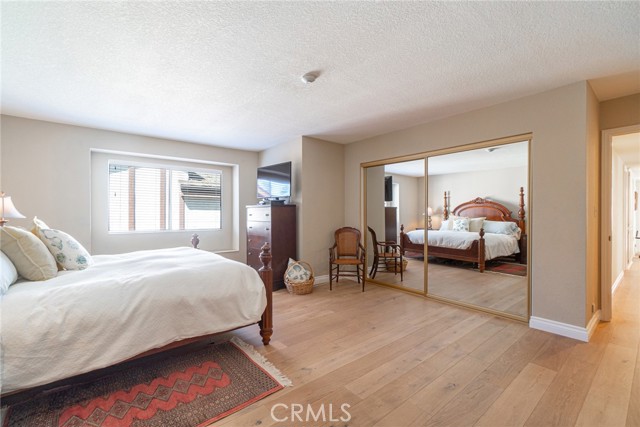 Large Primary Suite looking into the mirrored wardrobe doors and out to the hallway.