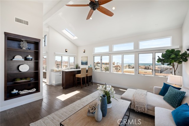 Sunlit living room with built-in bookcase and incredibly tall ceiling.