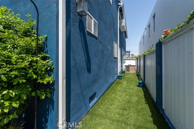 Unit 1 sideyard with artificial turf - perfect as a dog run.