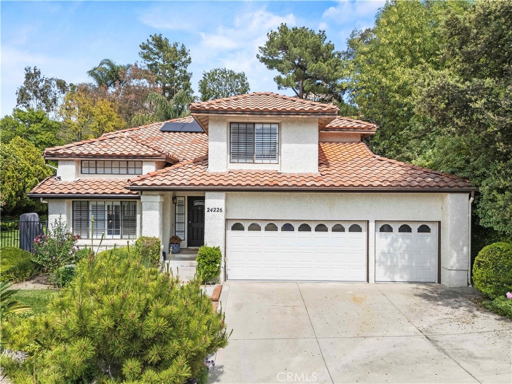 Beautifully updated Newhall home with standout curb appeal and a warm, inviting feel throughout. Inside, you’ll find soaring ceilings, wide-plank oak flooring, and a great layout that flows from the formal living room to the cozy family room with fireplace, wet bar, and wine fridge—perfect for relaxing or hosting guests.

The remodeled kitchen is the heart of the home, featuring a spacious center island with quartz counters, a farmhouse-style sink, stainless steel appliances, and recessed lighting. French doors open to a peaceful, private backyard ideal for gatherings.

A downstairs bedroom and stylishly updated full bath offer convenience, while upstairs you’ll find a generous primary suite with two walk-in closets, dual vanities, and a separate tub and shower. Three more bedrooms, a large full bath, and an upstairs laundry room with a utility sink round out the space.

Enjoy added peace of mind with a newer roof, HVAC system, and furnace (2023), plus an assumable solar lease at just $209.74/month. Plantation shutters throughout add style and privacy. This home has been lovingly maintained and is move-in ready!