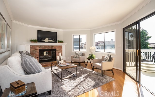 Living room with fireplace, access to deck.  Hardwood flooring