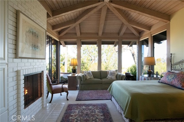 Primary Bedroom with cozy fireplace and built-in shelves with sitting area.