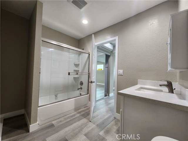 Full tub and shower with storage to the left for linens or surfboards!