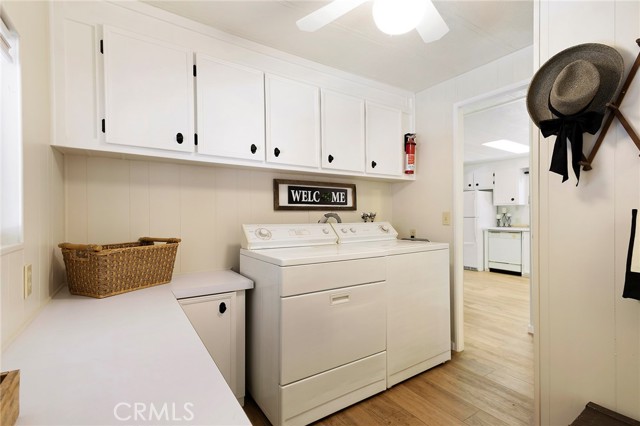 Laundry/Utility room with extended storage areas, with a door to both the common bath and carport