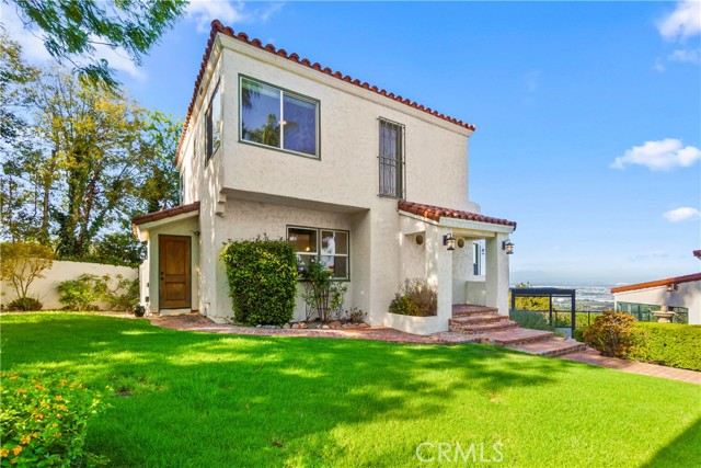 The lush lawn and landscaping add the home\'s charm.