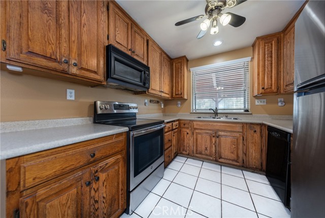 Kitchen with Ceiling Fan, Tile Flooring, Black Appliances & Stainless Refridge