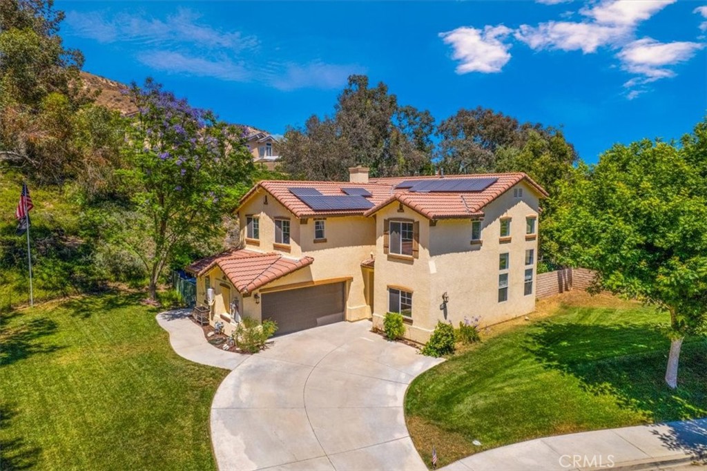 END OF CUL-DE-SAC POOL HOME on 28,000 sq ft lot! This uniquely oriented property with a large park-like front yard with mature trees, sprawling lawn and lush hillside shrubs is unparalleled in Castaic. Step inside to soaring vaulted ceilings over the spacious entertainer's living room with adjacent dining and direct access to the kitchen. Large high windows provide incredible natural light. Downstairs offers two bedrooms and a full bath. Kitchen is upgraded with granite counters and stainless steel appliances, Kitchen has a center island and built-in extra serving credenza, perfect for staging food for outdoor entertaining. The family room directly adjacent to the kitchen offers a cozy fireplace and media area for viewing your favorite entertainment. Upstairs is the spacious Primary Suite and Primary bath with dual sinks, glass shower and soaking tub and walk in closet. Secondary rooms are generous including the extra large front bedroom over the garage which could be divided and returned to the original 6th bedroom. Downstairs, step outside to this unique and sprawling outdoor living space. Custom designed rectangular pool and elevated spa with custom hardscape, built-in BBQ with bar seating and raised brick fire pit. Potential RV Parking. Newer HVAC system (2020) Lease Solar System. NO HOA and NO MELLO ROOS. Easy walk, bike or drive to Castaic Middle School and Castaic Elementary School. Minutes to shopping and Downtown Valencia Town Center. Quick access to 5 freeway for easy commuting. Must See this property to truly appreciate it!