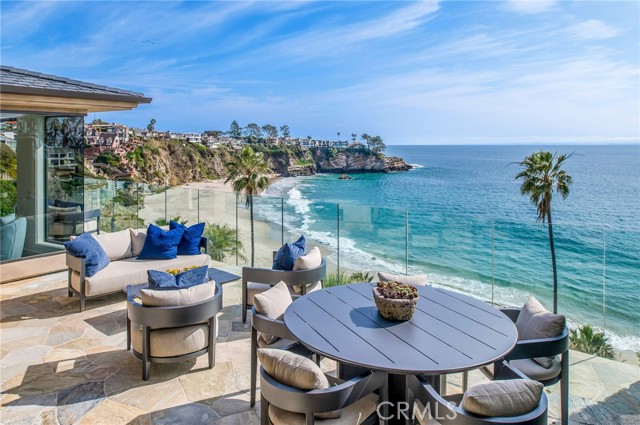 Experience the allure of South Laguna’s coveted Three Arch Bay in this newly furnished contemporary bluff front home. A private, guard-gated community offers exclusive access to a private beach and community amenities. Designed by Brion Jeanette and completely rebuilt in 2013, this estate underwent a refreshing update in 2022. The well-thought-out floor plan includes a main-level master suite plus 4 bedrooms and a bonus room. Drive up the long driveway to find ample parking and a three-car garage with an elevator leading to the first level. The private gated entry welcomes you to an entertaining courtyard boasting a waterfall spa, fire pit, and outdoor kitchen with a built-in BBQ and teppanyaki grill. A guest casita with a separate entry and a fully equipped home office enhance the property’s versatility. Glass double doors lead to the main level, showcasing expansive floor-to-ceiling Pacific Ocean views. Revel in the master suite with new hardwood floors, a walk-in closet, and a marble master bath with a steam shower. The main level also features a guest bath, a fully equipped kitchen with state-of-the-art appliances, a dining room, and a living room with a built-in bar. Bi-fold glass doors open onto the oversized deck, creating a seamless indoor/outdoor living space where you can watch dolphins, enjoy sunsets, or keep an eye on the kids playing below on the private beach. Descending to the lower level reveals two more ensuite bedrooms with ocean views, a bonus room, laundry, guest bath, and an entertainment/media area with a kitchenette/bar. This level opens onto the generous lower rear lawn with a fire pit, built-in seating, and electronic sunshades. Beach access is just steps away. The property is offered fully furnished with brand-new furnishings and a refreshed interior, making it the ideal home you’ve been anticipating.