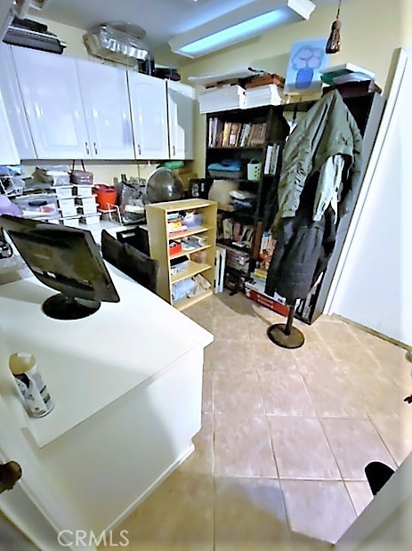 separate laundry room with built-ins cabinets and desk