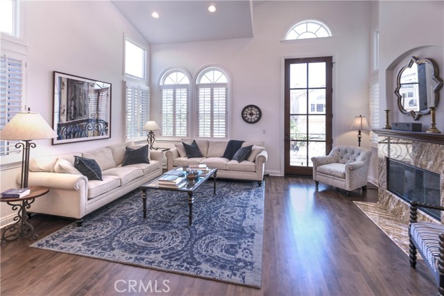 Fabulous Living Room with soaring ceiling, hardwood floors, extra tall doors, plantation shutters and fireplace