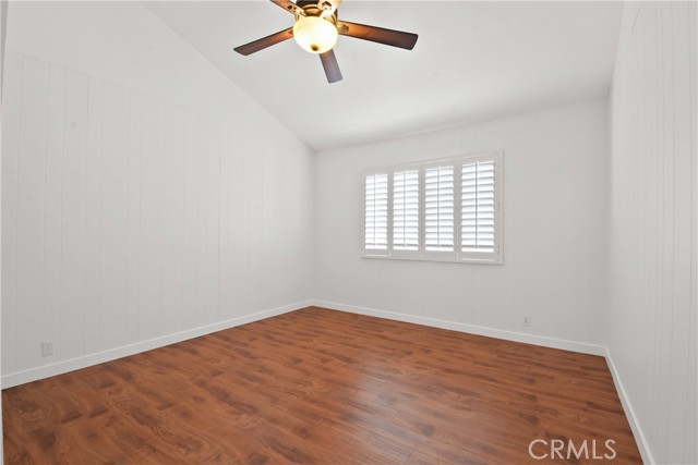 Front upstairs bedroom with decorative ceiling fan, and plantation shutters and recently installed laminate flooring