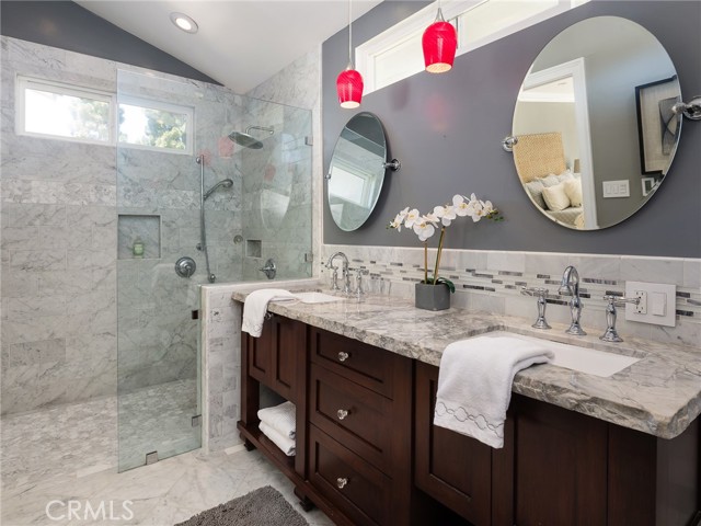 Master bathroom offers marble tile and quartzite countertop with custom built cabinet.