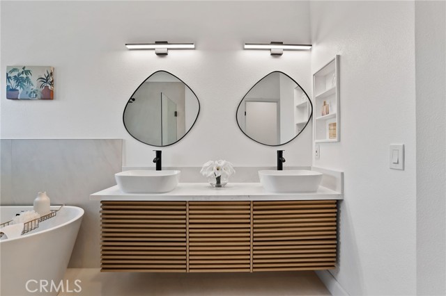 Floating vanities, mirros with irregular shape, white sink and the unique light fixtures, together with the wooden tone cabinet resulted in an one of kind bathroom!