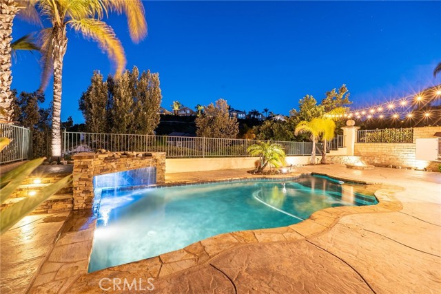 You do not want to miss this beautiful Stevenson Ranch pool home!  Located on a great street with incredible views from the backyard.  This popular floorplan features 5 bedrooms and 3 bathrooms with one of the bedrooms and a full bath with a walk-in shower downstairs.  As you enter the home you are greeted by beautiful, vaulted ceilings in the living room, custom wood built-ins and great natural light.  The kitchen looks out over the backyard and has been updated with marble counters, stainless steel appliances, custom cabinets and pendant lighting.  The large center island and walk-in pantry provide excellent storage as well.  The kitchen opens to the family room with built-in surround sound and a custom stacked stone fireplace. Large formal dining room and downstairs laundry room with sink.  Additional upgrades downstairs include travertine tile flooring, crown molding, custom stone accents and a built-in wine refrigerator and storage area.  The elegant iron staircase leads you to the second level with 3 additional secondary rooms and the spacious primary bedroom.  The upstairs hallway bathroom has been updated and offers dual sinks and a tiled, walk-in shower.  The primary suite has a massive bathroom with custom vanities, a large jacuzzi tub, separate shower and two walk-in closets.  There is a large deck off the primary bedroom with breathtaking views of Stevenson Ranch.  The backyard is perfect for entertaining with a sparkling pool, covered patio, firepit and built in BBQ area with room for several barstools.  OWNED SOLAR provides a HUGE savings on electricity.  Both HVAC units have been replaced.  The 3 car garage has newer epoxy floors and storage cabinets.  An incredible location just a short distance to the local elementary school and local park.  Minutes to the freeway and local shopping.