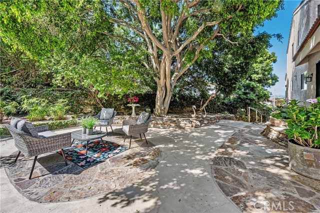 Lovely stone patio under a canopy of greenery.