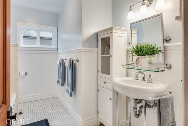 Hallway bath with beautiful wainscottting, white mosaic tile floor straight out of coastal living