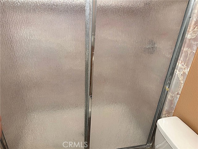 Primary shower stall with glass doors.