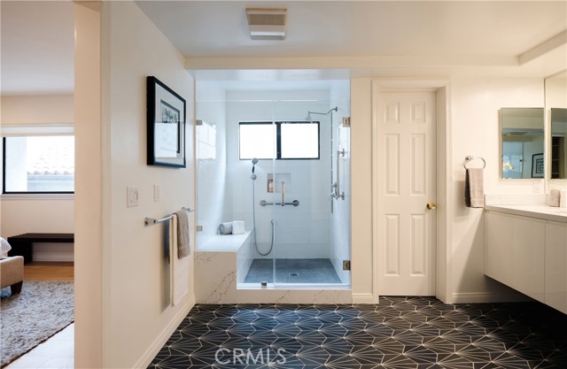 Remodeled primary bathroom with beautiful tile and quartz shower