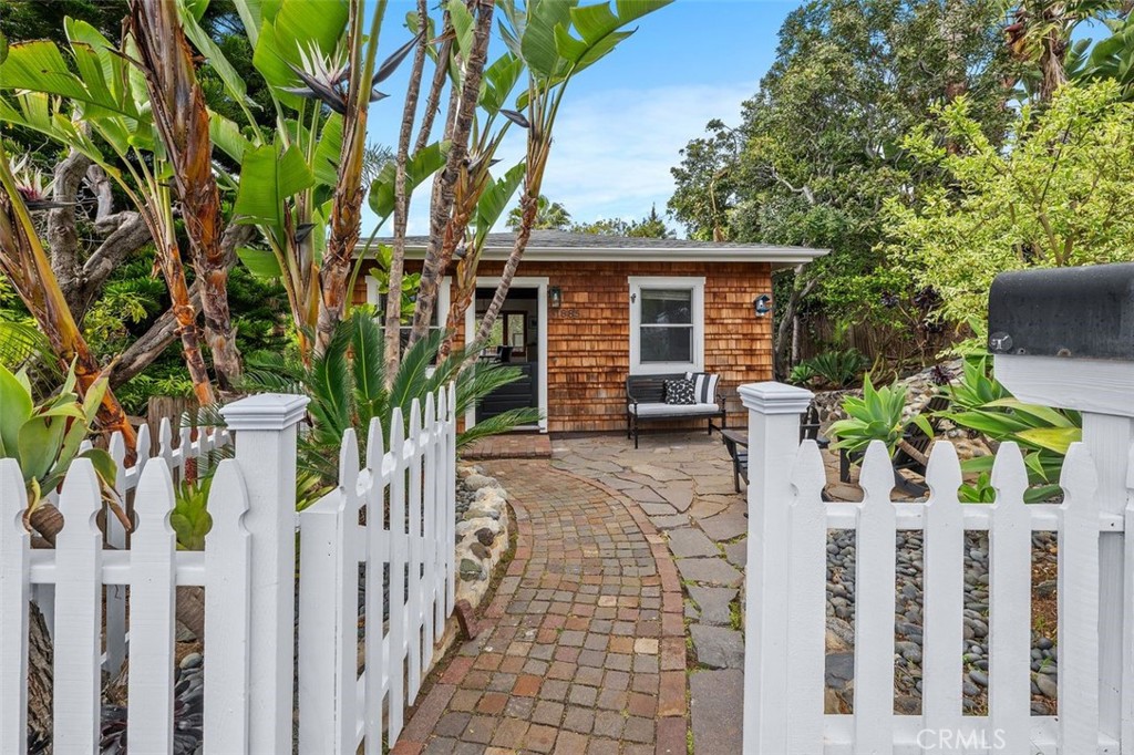 Nestled in the heart of South Laguna Village, this enchanting Cape Cod-style beach cottage
seamlessly blends historic charm with modern comforts. Originally built in 1929 and
thoughtfully expanded in 2006, the home offers 3 bedrooms and 3 bathrooms across 1,565
square feet of inviting living space. Situated on a rare 5,080 square foot lot, the property boasts a
spacious backyard—an uncommon luxury in this coastal enclave—perfect for barbecues, family
gatherings, or simply soaking up the Southern California sun. The open-concept upper level
features a sun-drenched living area with abundant windows, beamed ceilings, and seamless flow
between the kitchen, dining, and living spaces. Step out onto the ocean-view deck to enjoy
Pacific breezes and picturesque sunsets. The primary suite offers serene mornings with soft
sunlight and direct access to the deck overlooking the lush rear yard. Two additional bedrooms
provide private entries and access to an outdoor shower—ideal for rinsing off after a quick 3-
minute stroll to the renowned Thousand Steps Beach. Additional features include radiant heating,
tile and wood flooring, a detached one-car storage garage, and proximity to parks, schools,
restaurants, and shopping. Experience the quintessential Laguna Beach lifestyle in this timeless
coastal retreat.