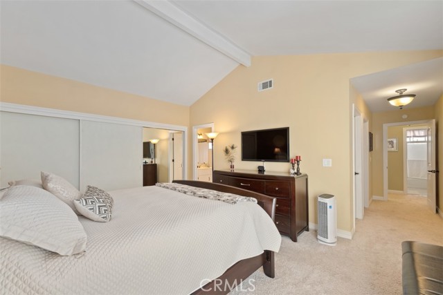 Master bedroom with high ceilings, sliding door to attached balcony, walk in closet and 3 mirrored door closet and storage.