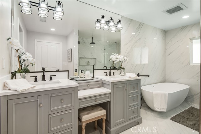 Primary bathroom vanity, two sinks, large soaking tub, large walk-in shower.