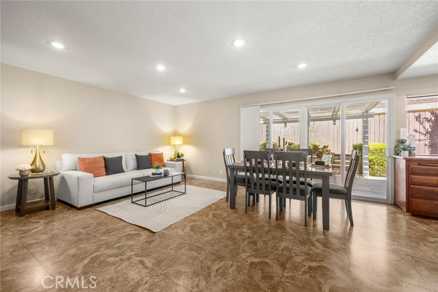 Sliding glass doors flood both spaces with natural light and lead to a private covered patio, ideal for outdoor dining, entertaining or relaxing.