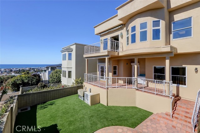Exterior view of the homes back yard with artificial turf, patio area and the beautiful ocean view